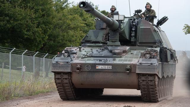 Zwei Soldaten fahren auf einem Panzer von der Bundes-Wehr. 