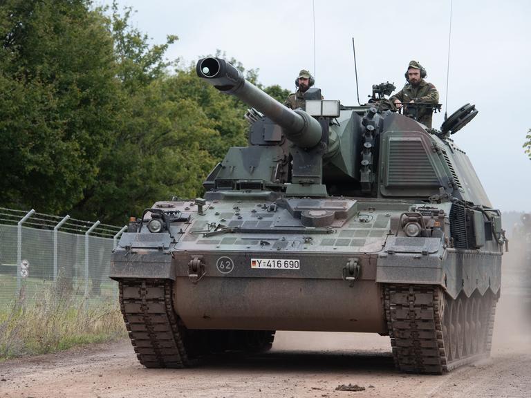 Zwei Soldaten fahren auf einem Panzer der Bundeswehr. 