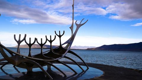 Blick zu früher Abendstunde auf die Edelstahlskulptur, die Richtung Meer weist.