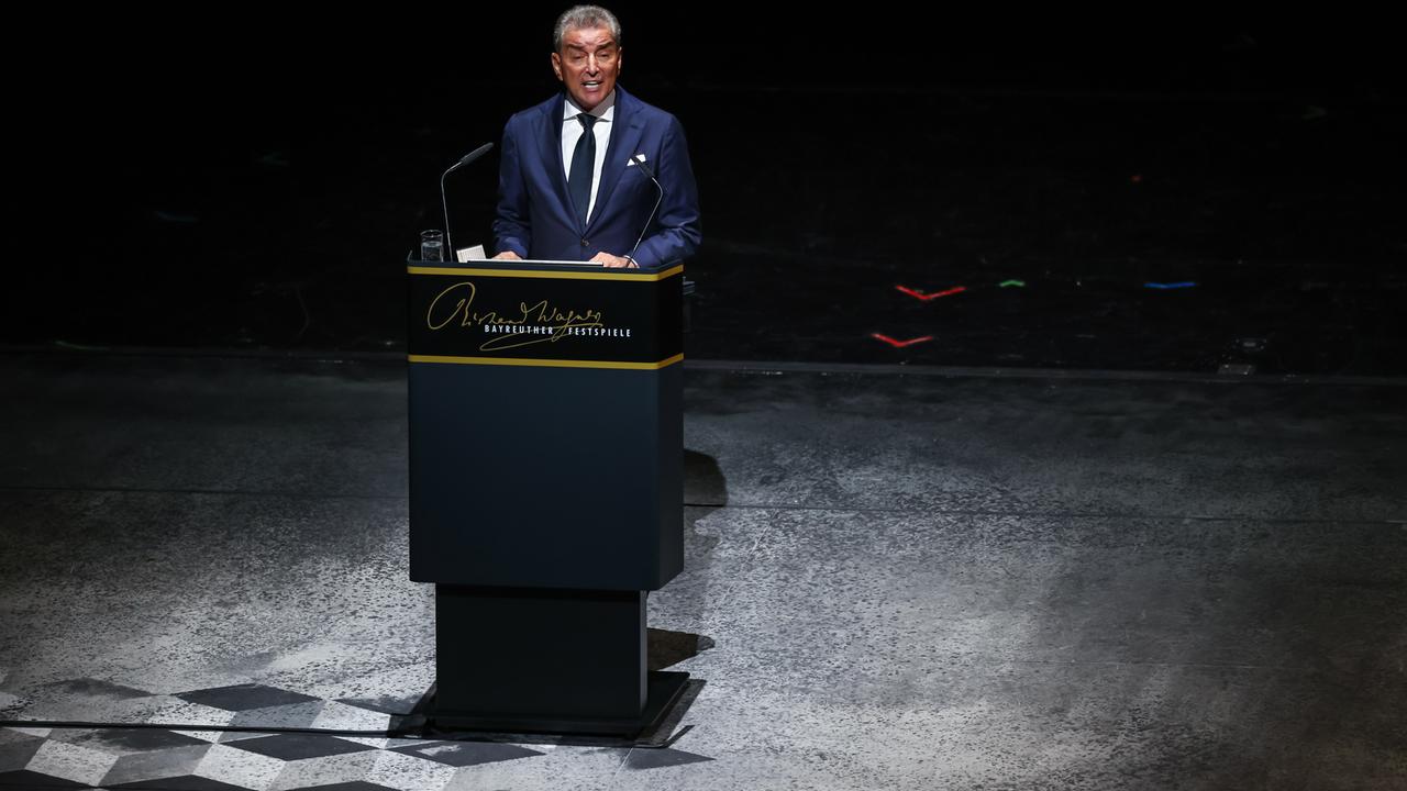 Michel Friedman steht in einer dunklen Umgebung an einem Redepult und spricht in ein Mikrofon.