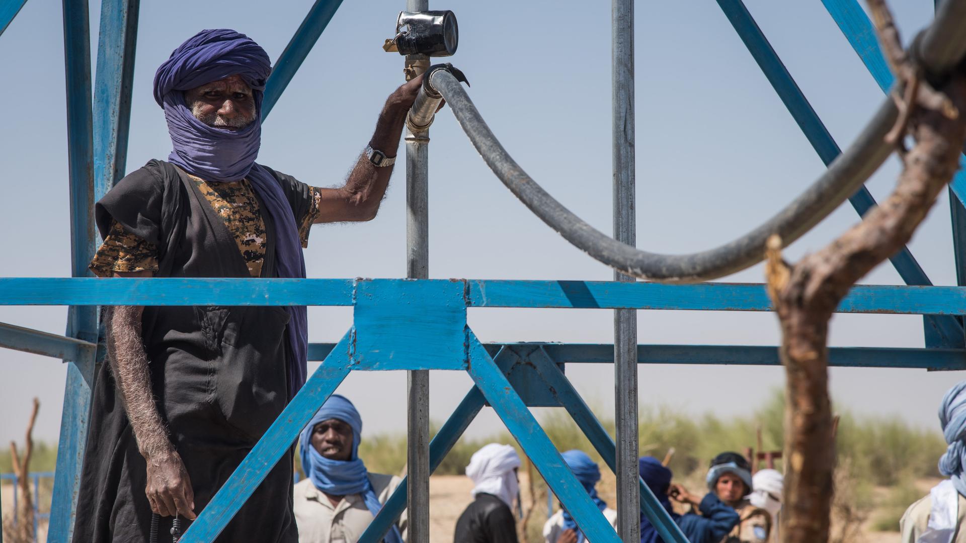 Ein malischer Mann steht an einer Bewässerungsanlage, die durch Entwicklungshilfe ermöglicht wurde.