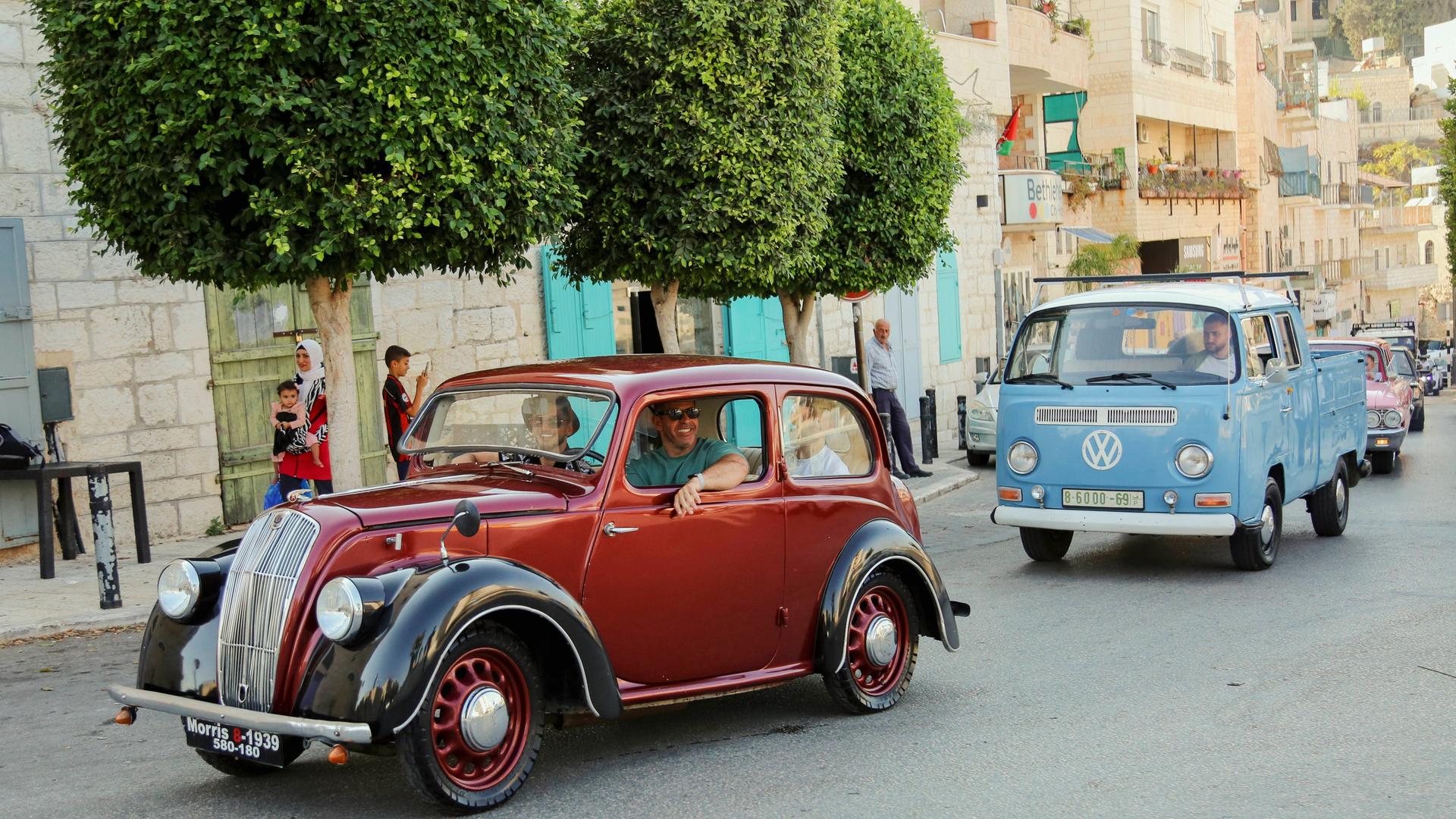 Ein Oldtimer und ein alter VW-Bulli fahren durch die Straßen von Jerusalem. Ein Oldtimer und ein alter VW-Bulli fahren durch die Straßen von Jerusalem.