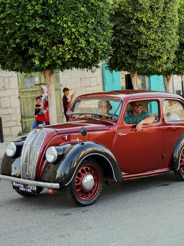 Ein Oldtimer und ein alter VW-Bulli fahren durch die Straßen von Jerusalem. Ein Oldtimer und ein alter VW-Bulli fahren durch die Straßen von Jerusalem.