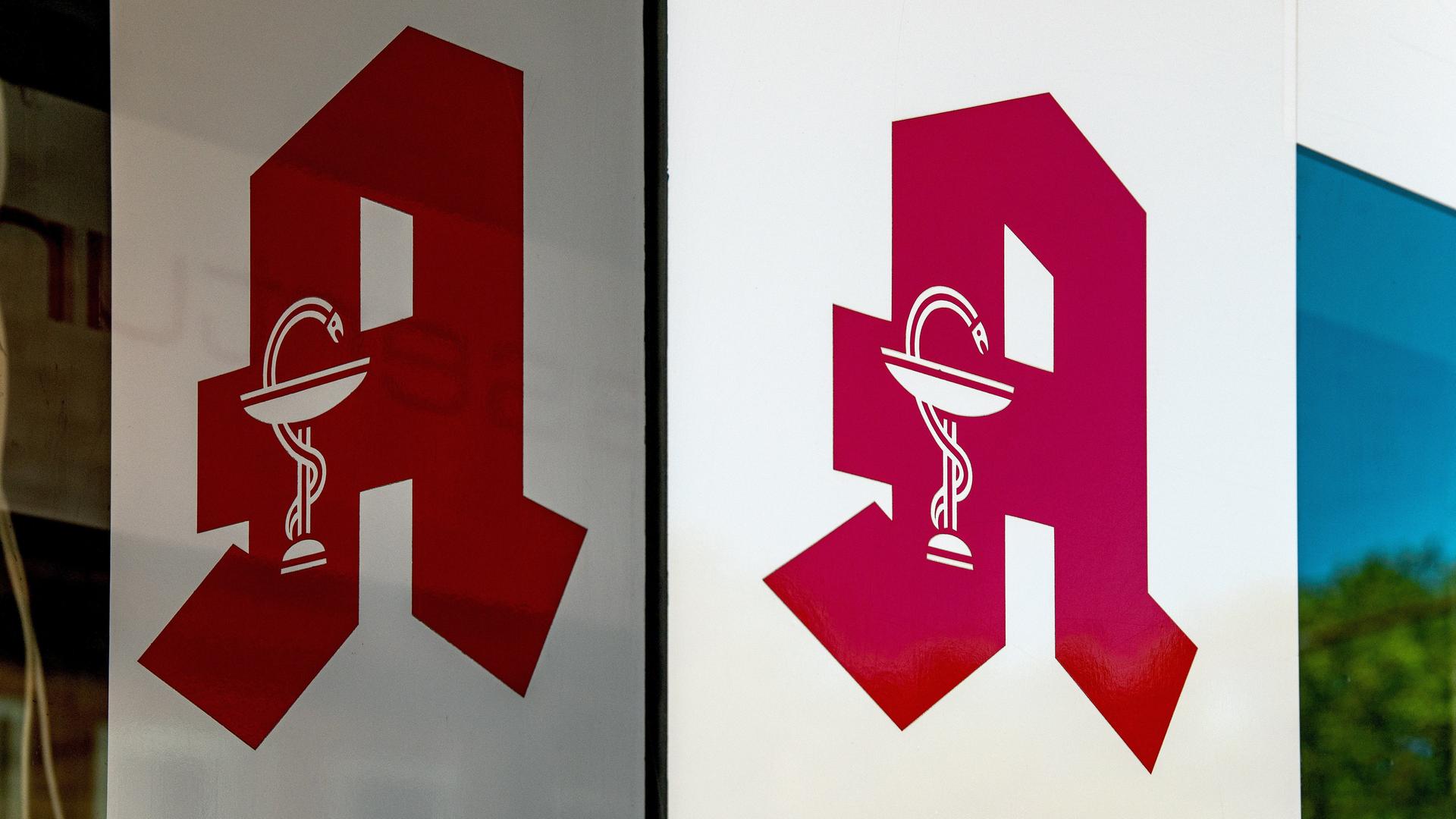 Auf einem Schild ist das rote Logo der Apotheken - ein "A" in Frakturschrift - zu sehen.