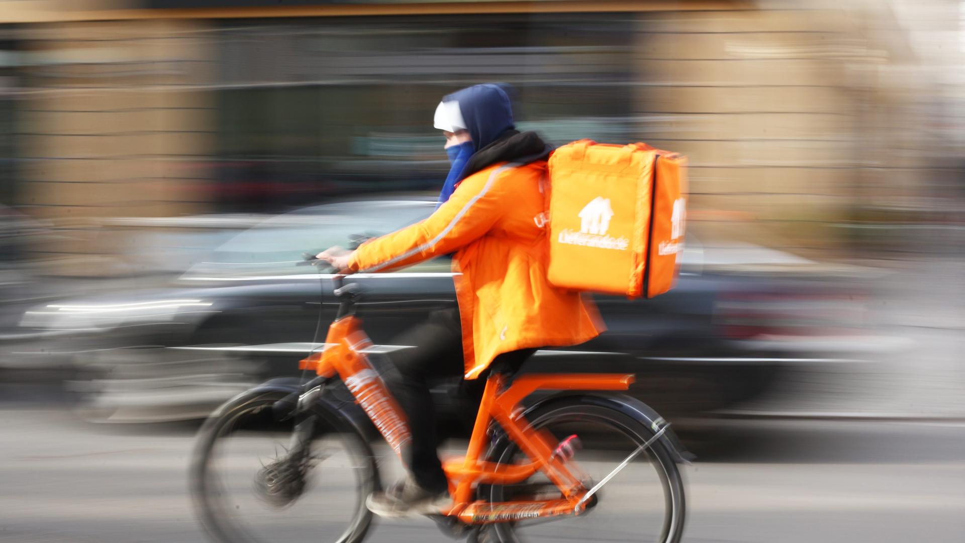 Ein Fahrer von Lieferando fährt auf seinem Rad in Berlin im Bezirk Mitte auf der Friedrichstraße