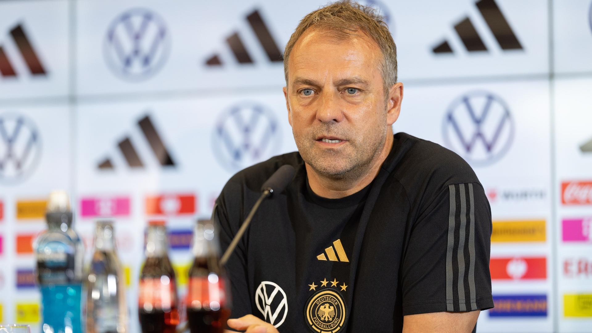 Bundestrainer Hansi Flick spricht in der Pressekonferenz der Fußball-Nationalmannschaft. Er sitzt vor einem Mikrofon. Bundestrainer Hansi Flick spricht in der Pressekonferenz der Fußball-Nationalmannschaft. Er sitzt vor einem Mikrofon.
