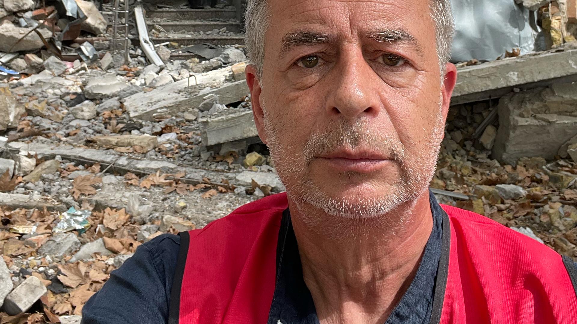 Andreas Tölke macht ein Selbstportrait vor einem zerstörten Haus in der Ukraine Andreas Tölke macht ein Selbstportrait vor einem zerstörten Haus in der Ukraine