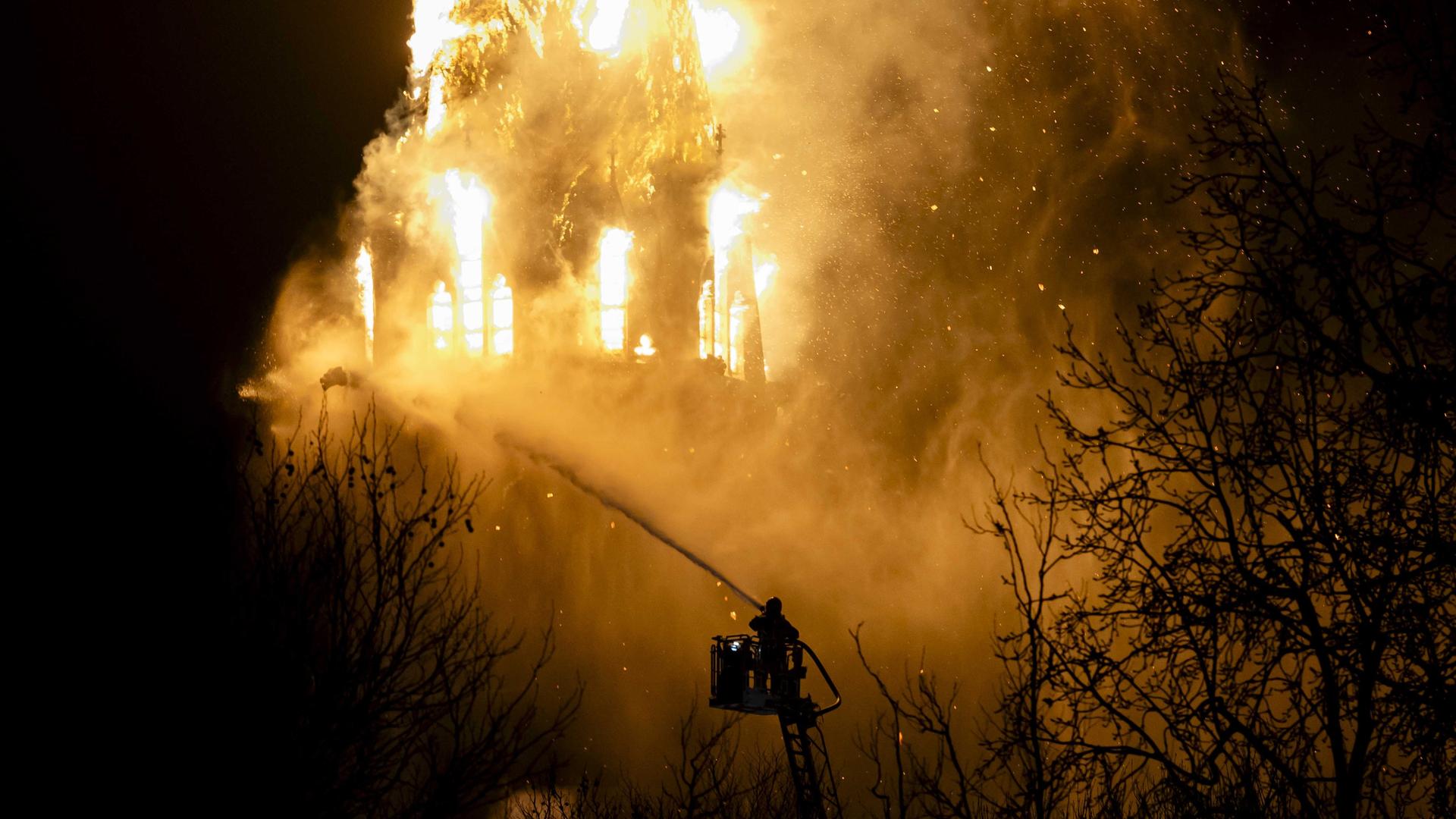 Einsatzkräfte der Feuerwehr löschen die brennende Vondelkirche in der Nähe des Vondelparks in Amsterdam. Einsatzkräfte der Feuerwehr löschen die brennende Vondelkirche in der Nähe des Vondelparks in Amsterdam.
