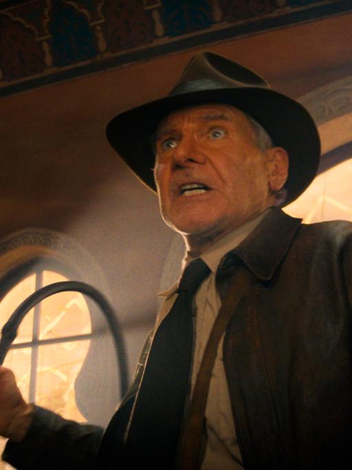 Der US-Schauspieler Harrison Ford in einer Szene der Films "Indiana Jones und das Rad des Schicksals" in seinem Kostüm und mit der Peitsche in der Hand. 