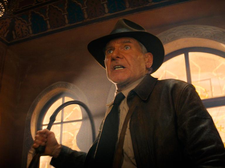 Der US-Schauspieler Harrison Ford in einer Szene der Films "Indiana Jones und das Rad des Schicksals" in seinem Kostüm und mit der Peitsche in der Hand. 