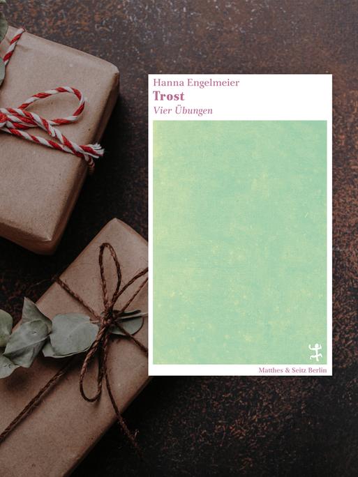 Buchcover "Trost. Vier Übungen" von Hanna Engelmeier auf einem Fotohintergrund, auf dem weihnachtlich verpackte Geschenke zu sehen sind.