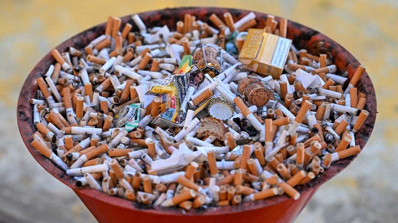 Eine Schale voller Kippen und Zigarettenschachteln.