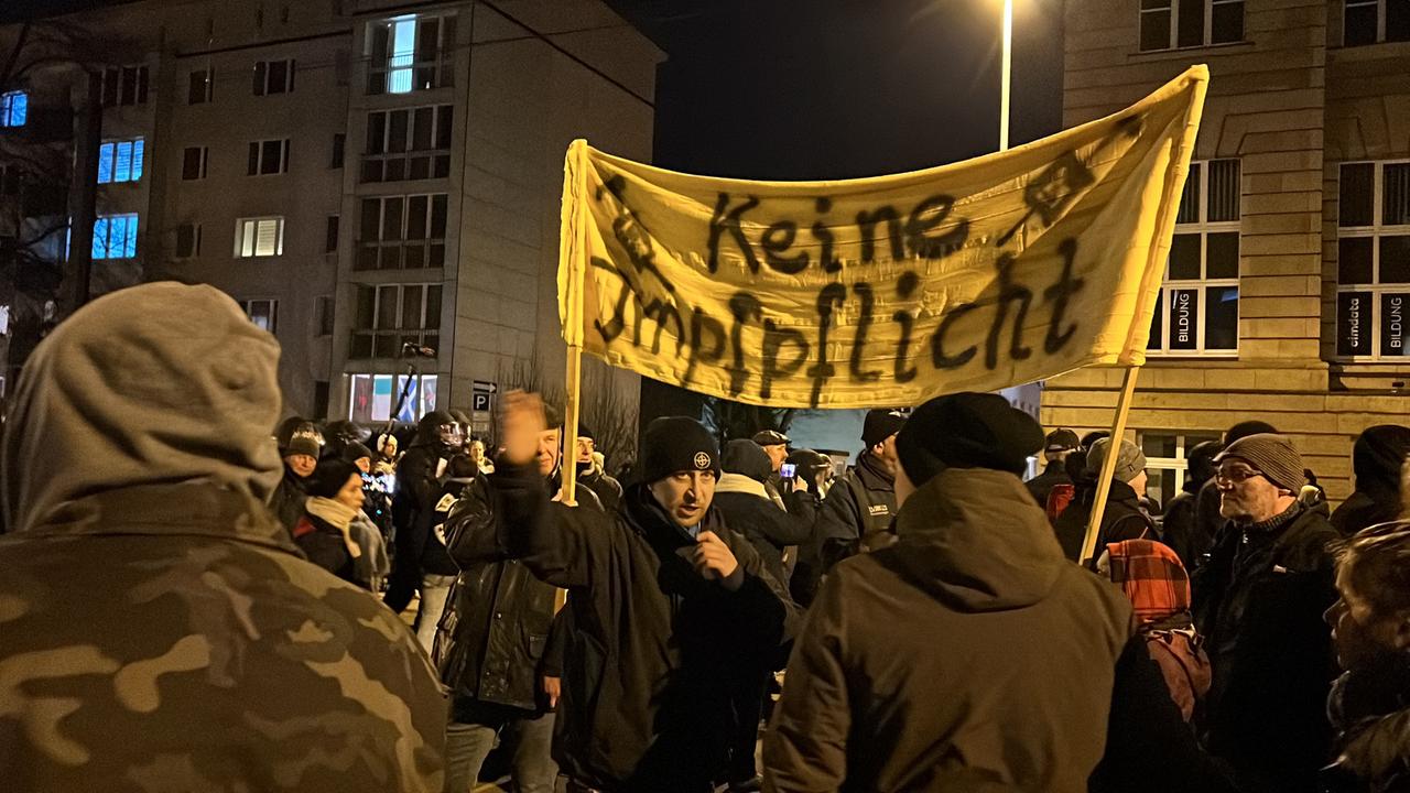 Teilnehmer einer Demonstration gegen die Maßnahmen zur Eindämmung der Corona-Pandemie halten ein Transparent mit der Aufschrift "Keine Impfpflicht".