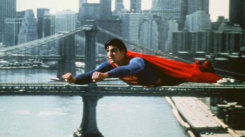 Christopher Reeve im blau-roten Supermankostüm fliegt über New York City in einem Superman-Film von 1980 Christopher Reeve im blau-roten Supermankostüm fliegt über New York City in einem Superman-Film von 1980