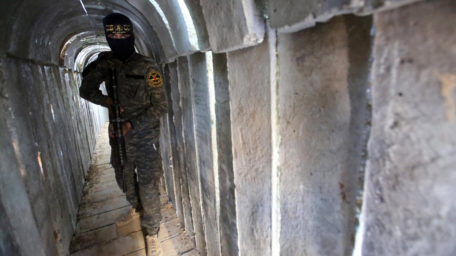 Ein bewaffneter Mann in Uniform steht im Tunnelsystem im Gazastreifen.