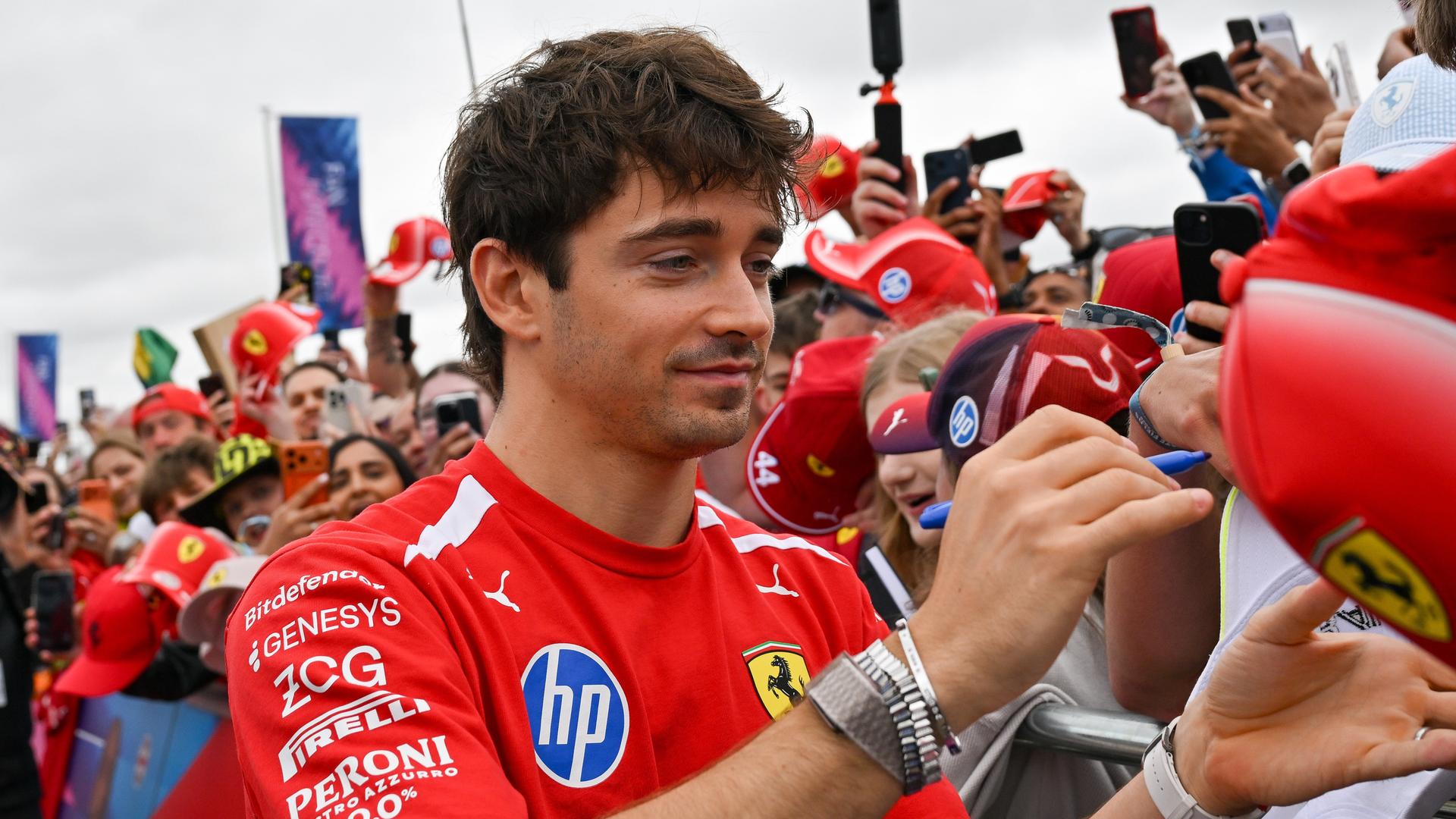 Formel-1: Charles Leclerc siegt in Silverstone; er steht in einer Menge von Zuschauern und gibt Autogramme. Formel-1: Charles Leclerc siegt in Silverstone; er steht in einer Menge von Zuschauern und gibt Autogramme.