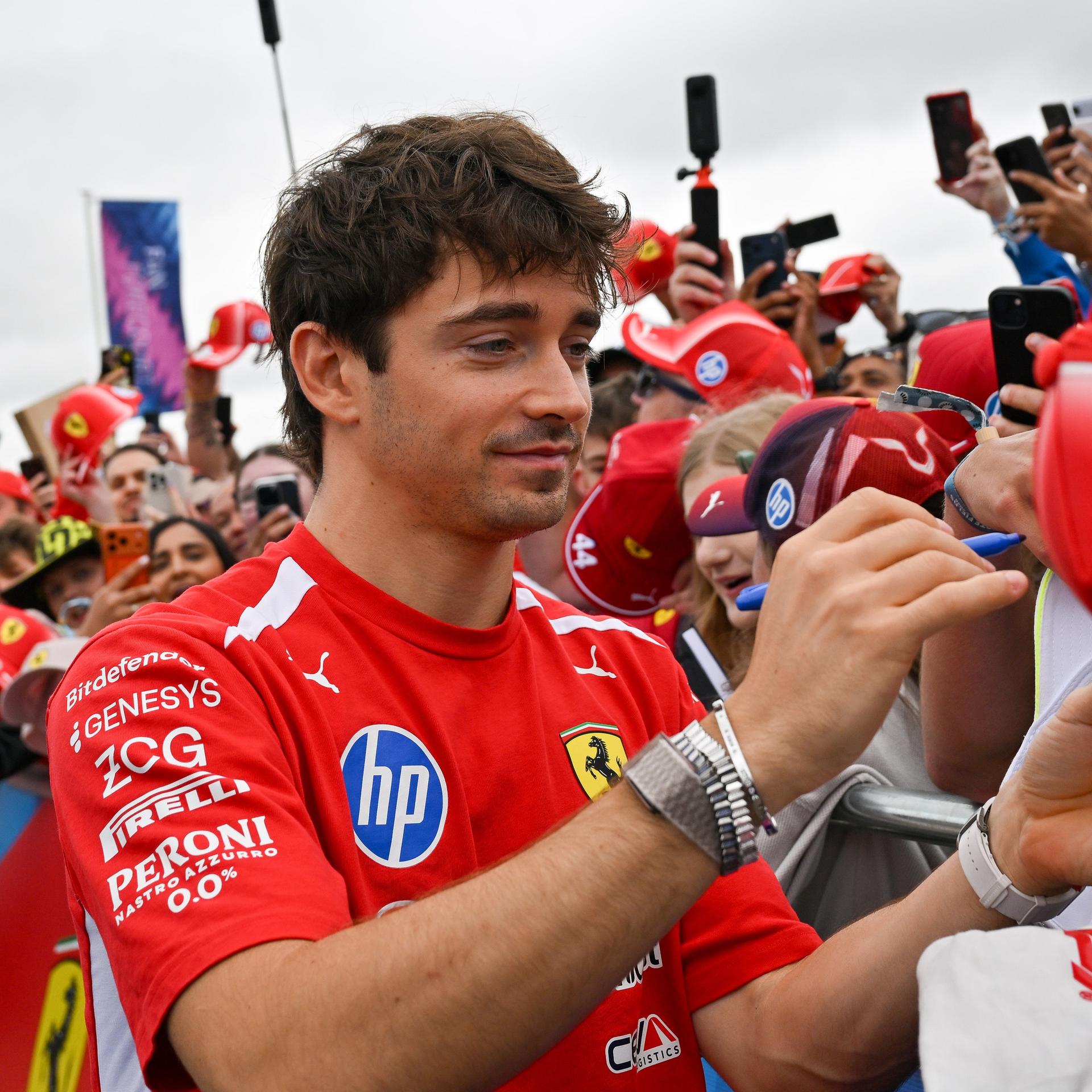 Formel-1: Charles Leclerc siegt in Silverstone; er steht in einer Menge von Zuschauern und gibt Autogramme.