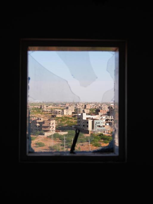 Ausblick auf eine ost-afrikanische Stadt durch ein zersplittertes Fenster