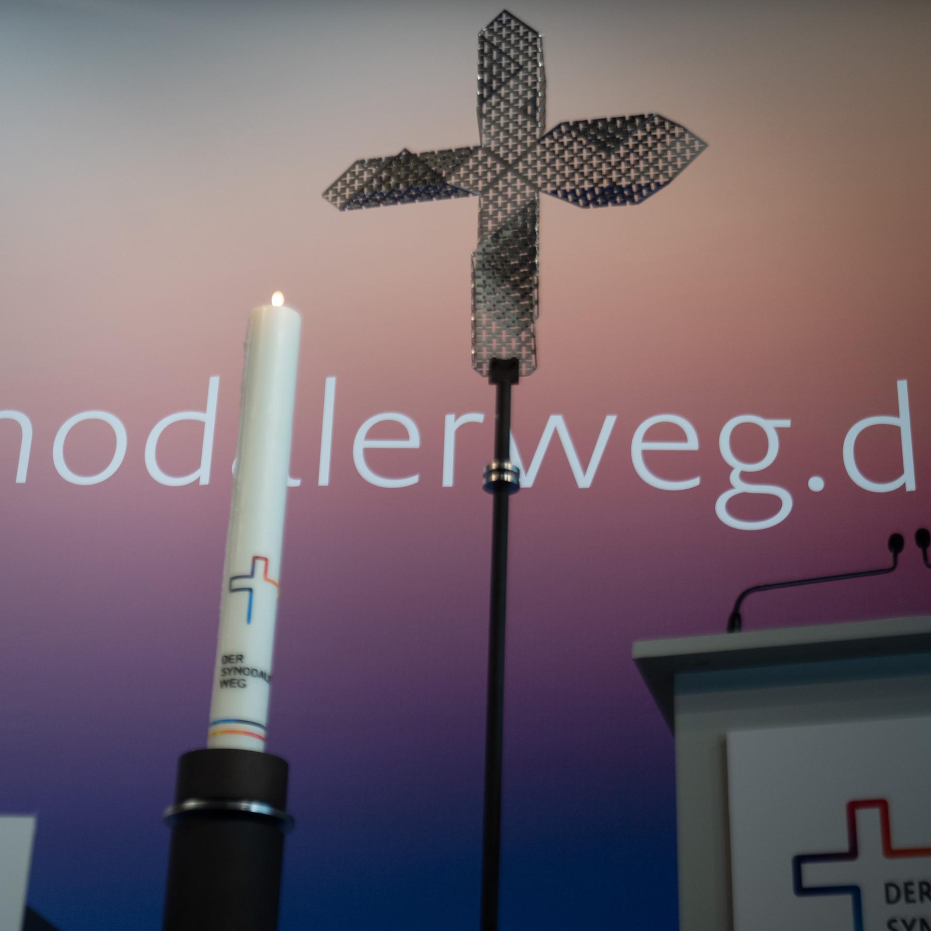 Eine Kerze und ein Kreuz stehen zu Beginn der Dritten Synodalversammlung der deutschen Katholiken vor dem Schriftzug "synodalerweg.de". 