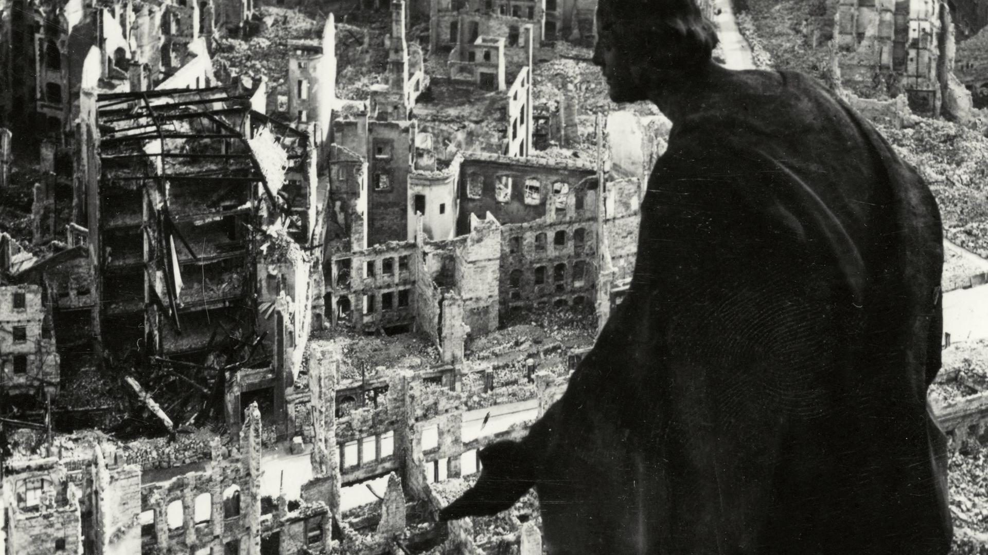 Dresden. Blick vom Rathausturm auf das während des Zweiten Welkriegs fast völlig zerstörte Dresden. Im Vordergrund eine Steinskulptur, die einem Engel gleicht und auf die Stadt hinunterschaut. 