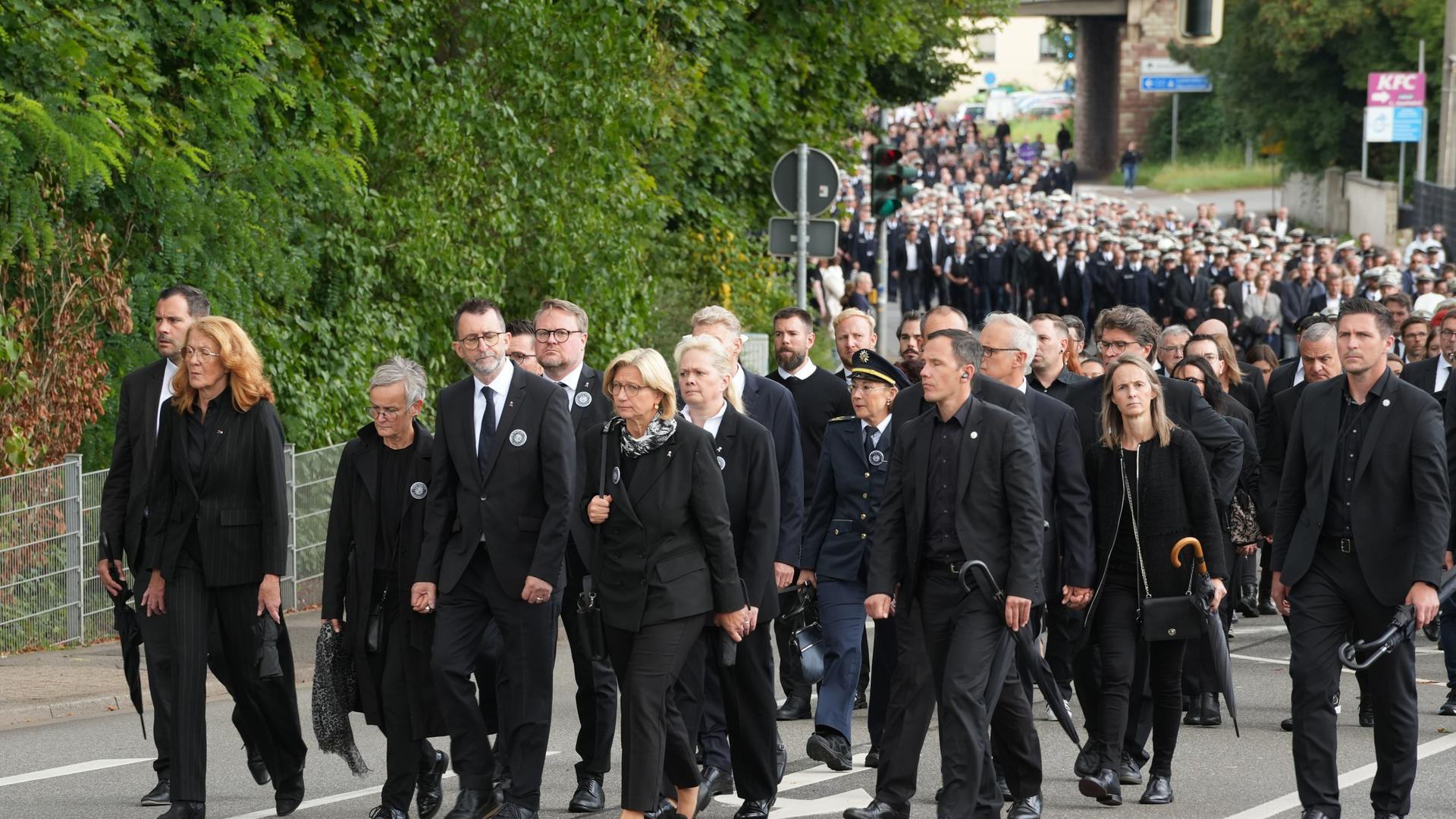 Ministerpräsidentin Anke Rehlinger und Innenminister Reinhold Jost (M, beide SPD) gehen mit Trauergästen und zahlreichen Polizisten in einem Trauermarsch für den in Völklingen erschossenen Polizisten, Polizeioberkommissar Simon B., zur Beisetzung.