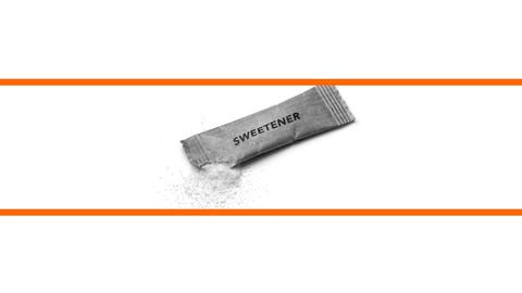 Schwarz-weißes Bild von einem Sachez Süßstoff vor weißem Hintergrund im mittleren Drittel des Bildes. Die beiden weißen Bilddrittel oben und unten sind mit orangenen Streifen abgetrennt.