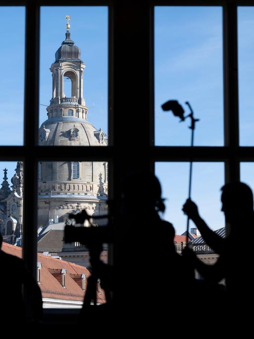 Journalisten zeichnen sich im Residenzschloss während einer Pressekonferenz vor der Frauenkirche als Silhouetten ab. Journalisten zeichnen sich im Residenzschloss während einer Pressekonferenz vor der Frauenkirche als Silhouetten ab.