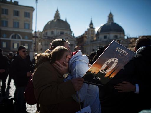 Opfer von Missbrauch und Aktivisten in Rome bei einer Demonstration zur Aufklärung kirchlicher sexueller Gewalt; ein Mensch weint an der Schulter einer Demonstrantin (23. Februar 2023)