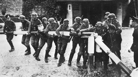 Beim Einmarsch deutscher Truppen in Polen am 1.9.1939 reißen Soldaten der deutschen Wehrmacht einen Schlagbaum an der deutsch-polnischen Grenze nieder.