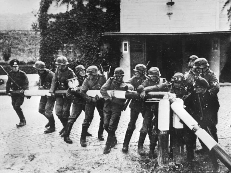 Beim Einmarsch deutscher Truppen in Polen am 1.9.1939 reißen Soldaten der deutschen Wehrmacht einen Schlagbaum an der deutsch-polnischen Grenze nieder.