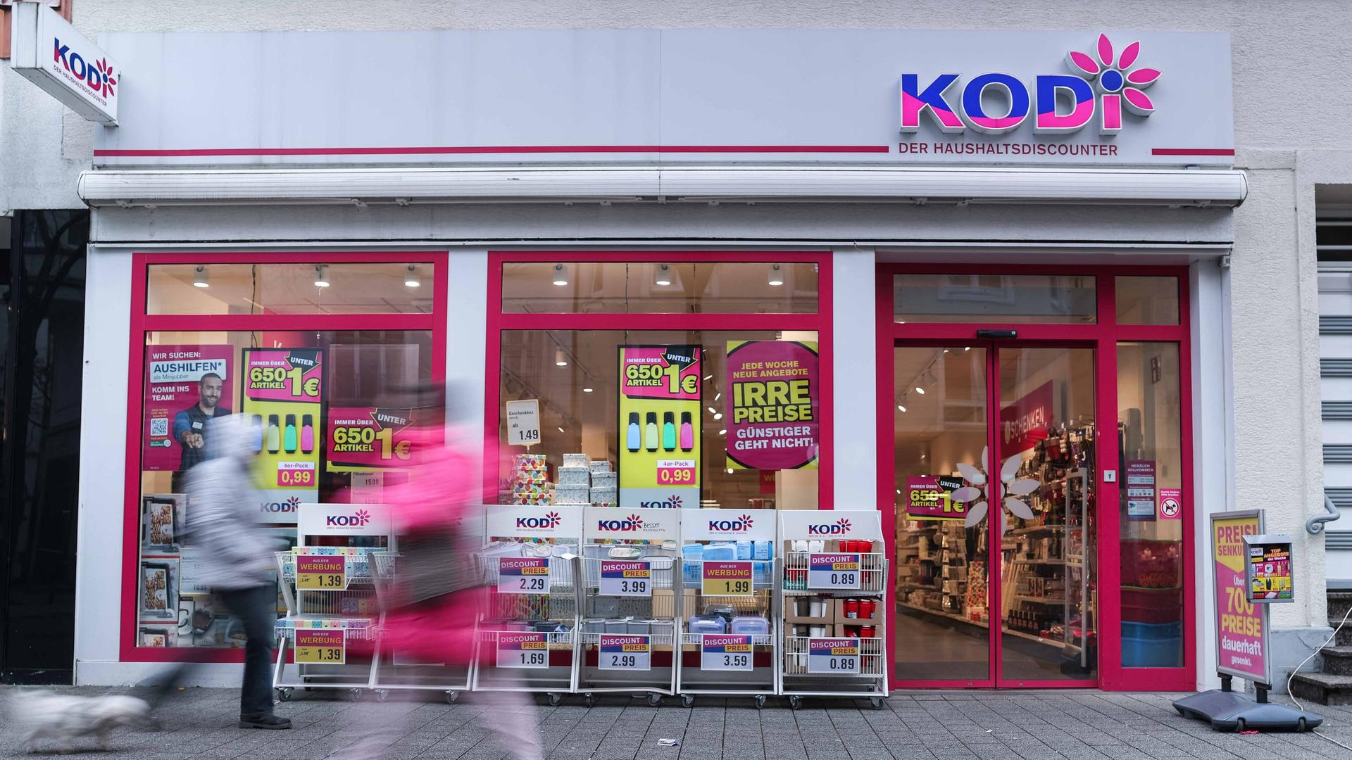 Eine Filiale des insolventen Discounters Kodi; vor dem Laden gehen zwei Passanten entlang.