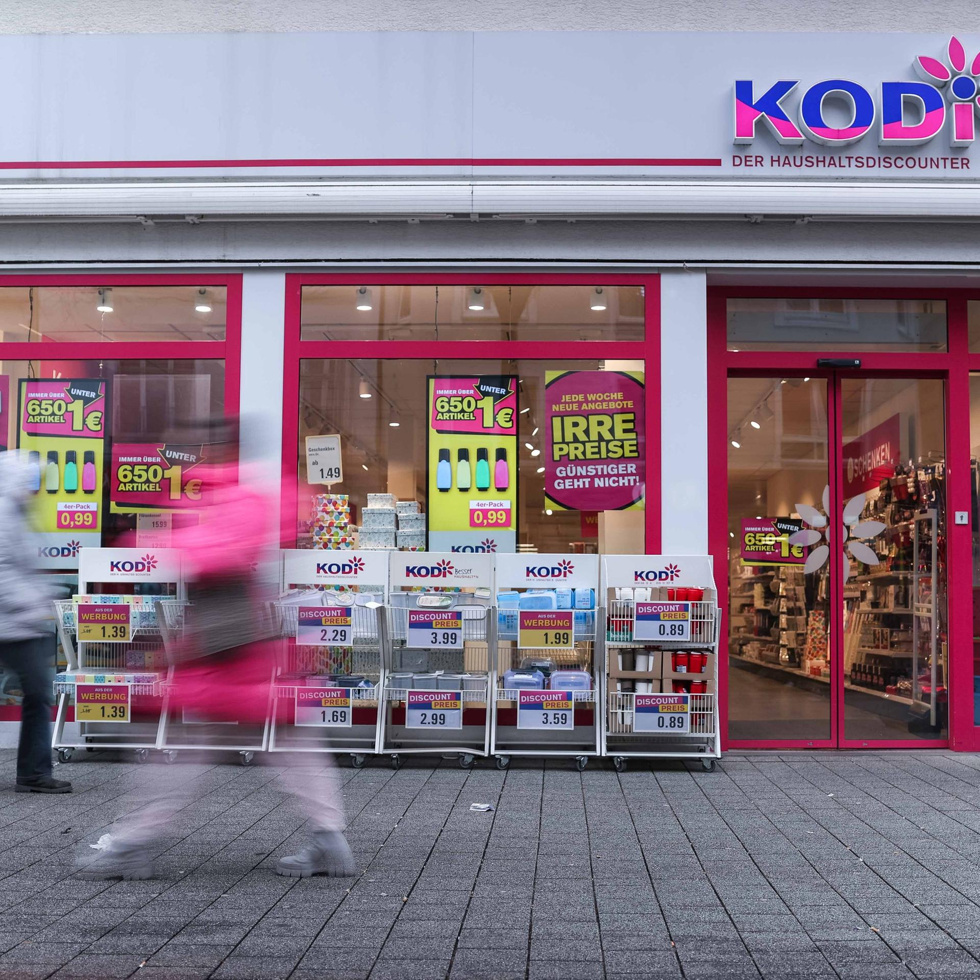 Eine Filiale des insolventen Discounters Kodi; vor dem Laden gehen zwei Passanten entlang.