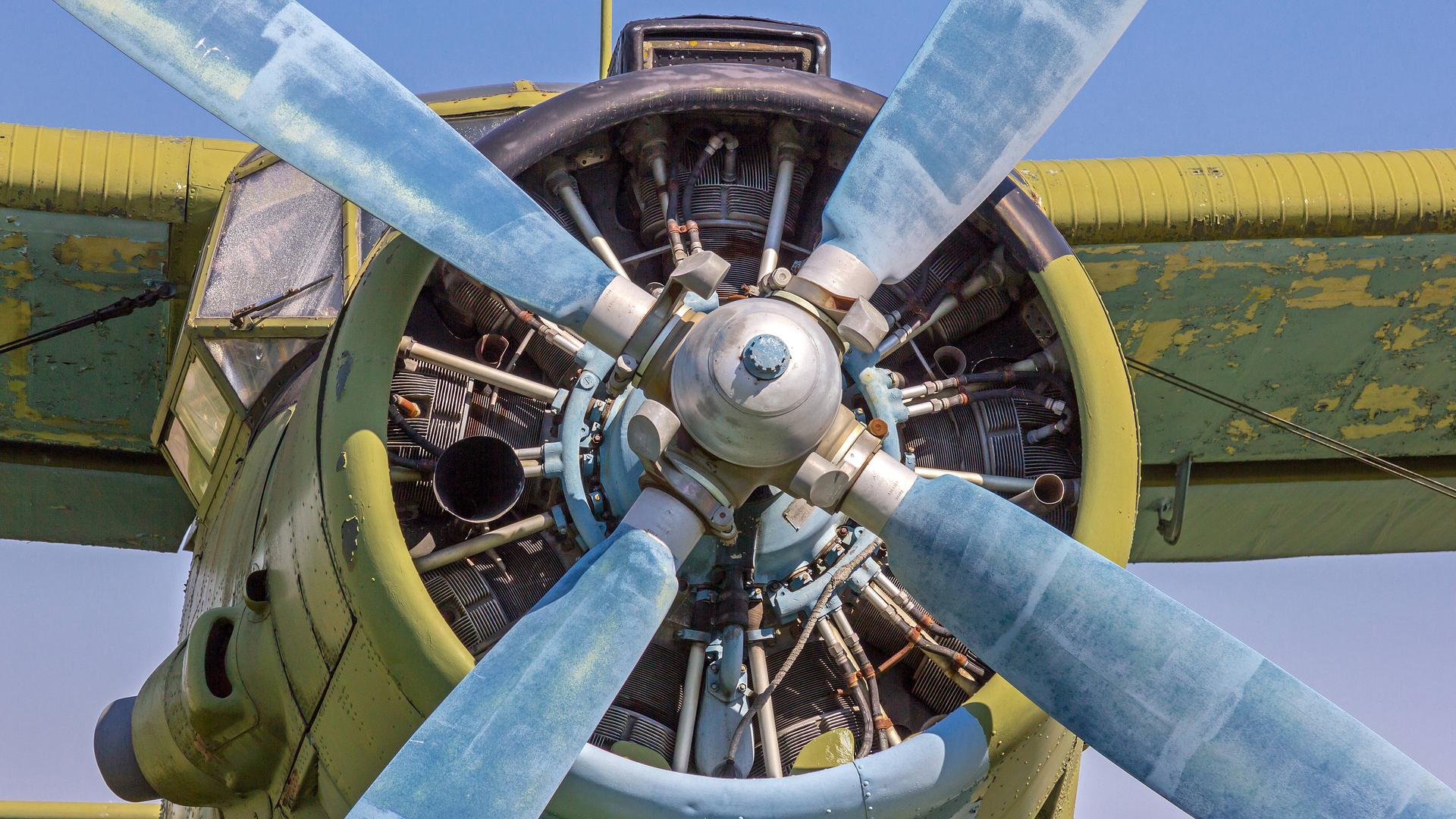 Blick auf das Zentrum eines Sternmotors, an dem vier blaue Rotorblätter befestigt sind.
