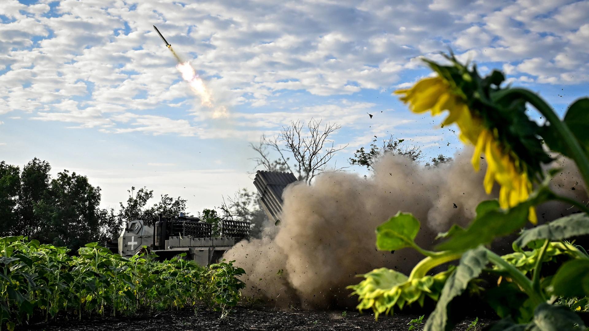 Aus einem Sonnenblumenfeld in der Ukraine wird Artillerie abgefeuert. Das Geschoss ist am Himmel sehr gut zu erkennen.