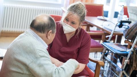 Eine Pflegerin betreut eine Bewohnerin eines Pflegeheims