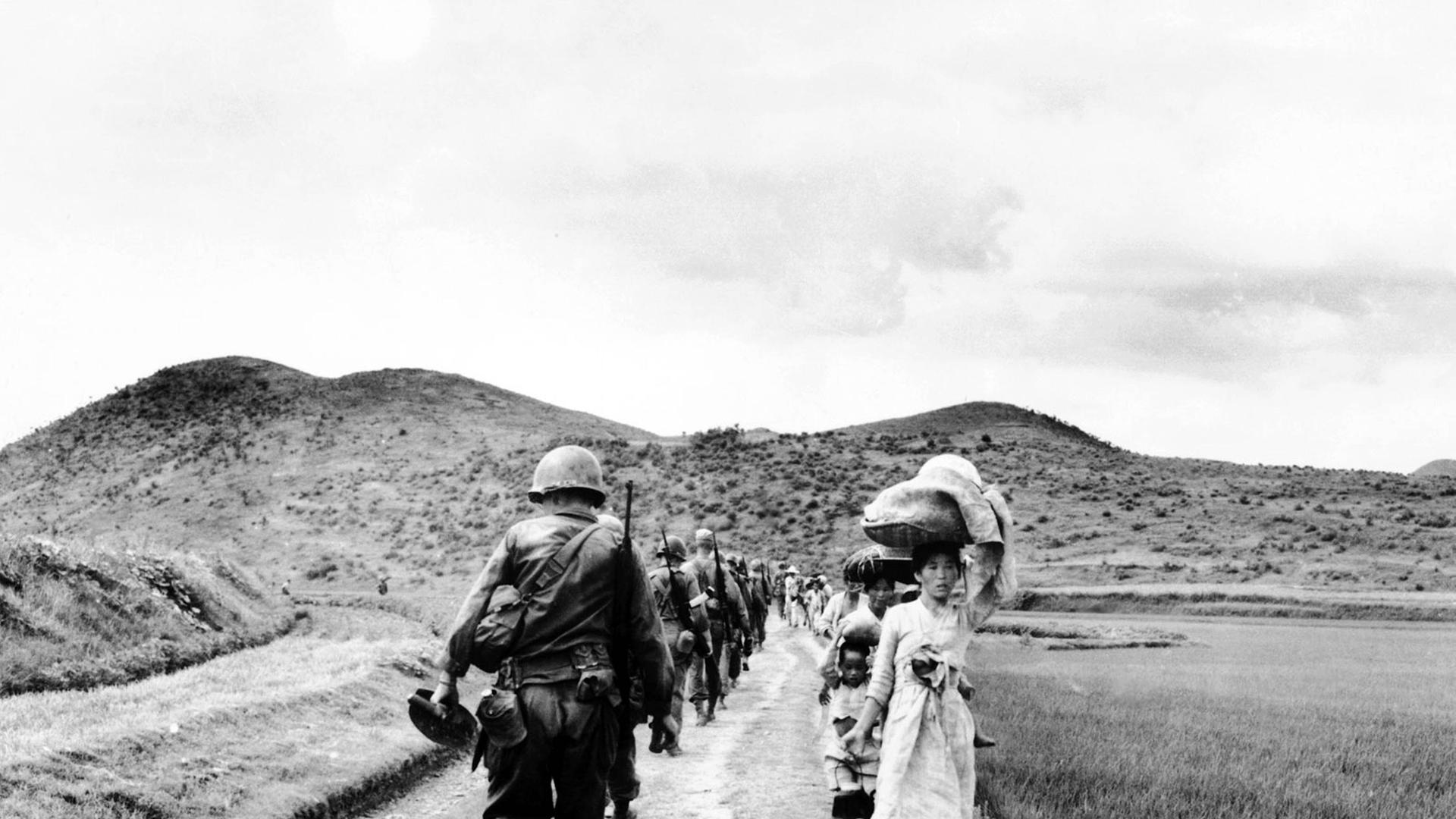 Frauen und Soldaten an einem koreanischen Feld.