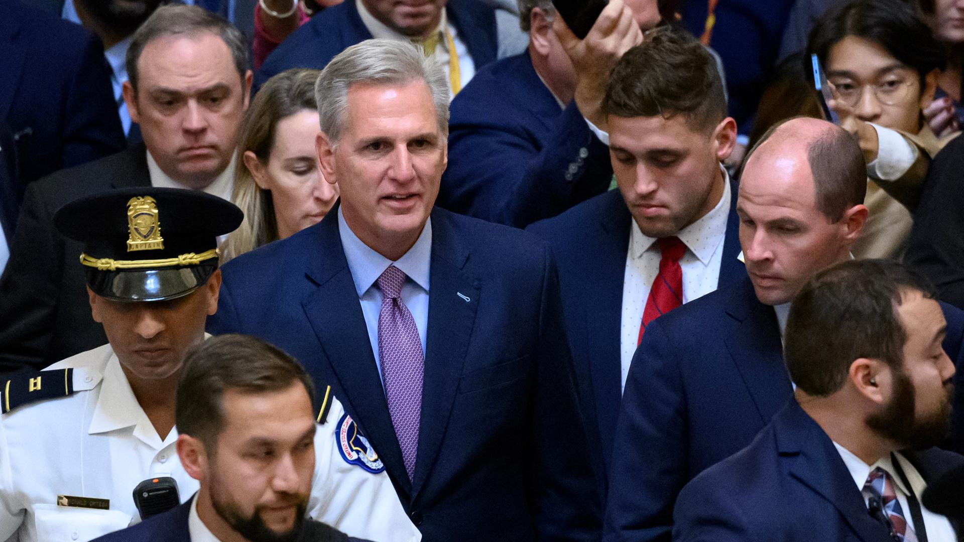 US-Parlamentssprecher Kevin McCarthy zeigt sich schockiert nach seiner Abwahl, umgeben von Abgeordneten, die aus dem Saal strömen