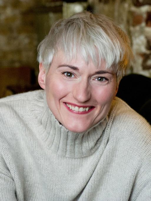 Die Schauspielerin Karola Oswald lacht herzlich.