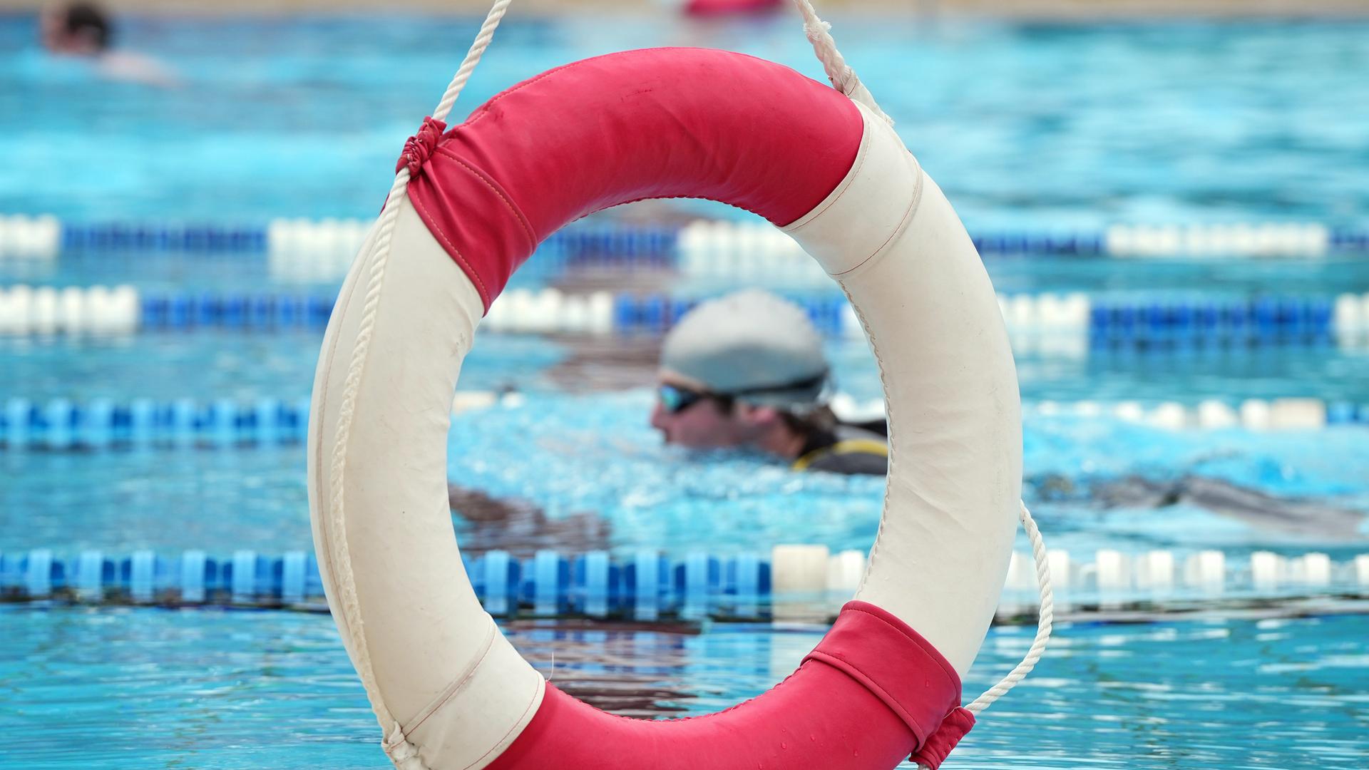 Ein Rettungsring hängt im Sommerbad Humboldthain am Rand des Beckens.