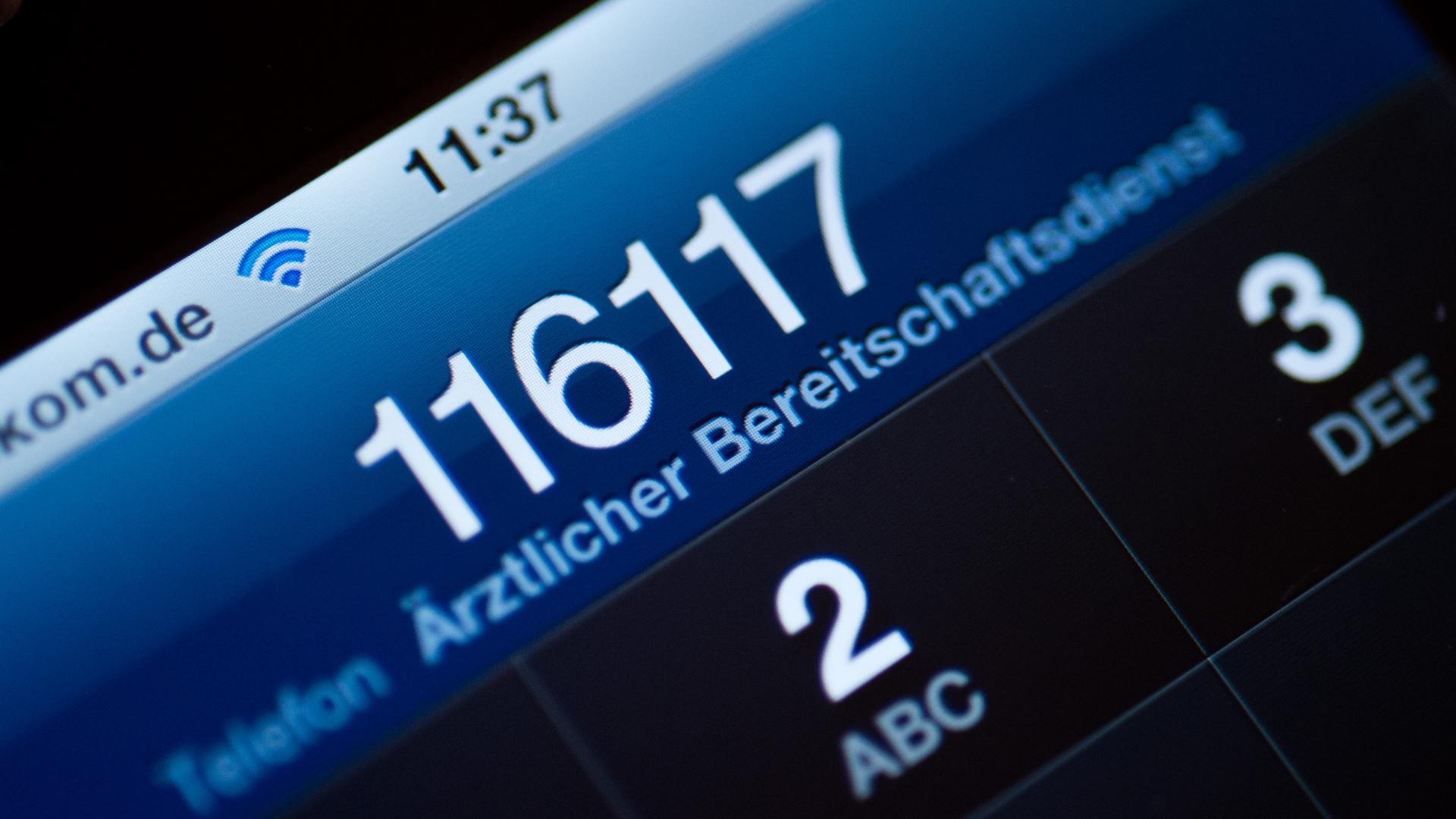 Die Telefonnummer 116117 des ärztlichen Bereitschaftsdienstes ist auf dem Display eines Smartphones zu lesen.