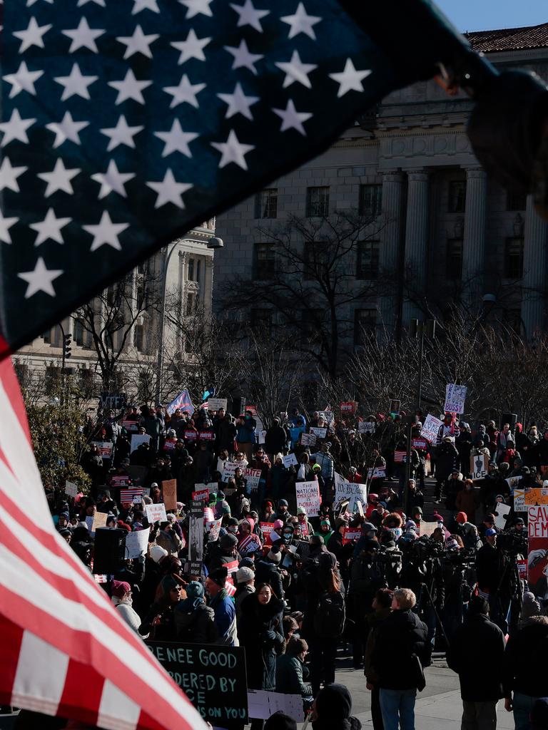 Durch eine verkehrt herum gehaltene Flagge der UA hindurch sind auf einem Platz versammelte Demonstranten zu sehen.
