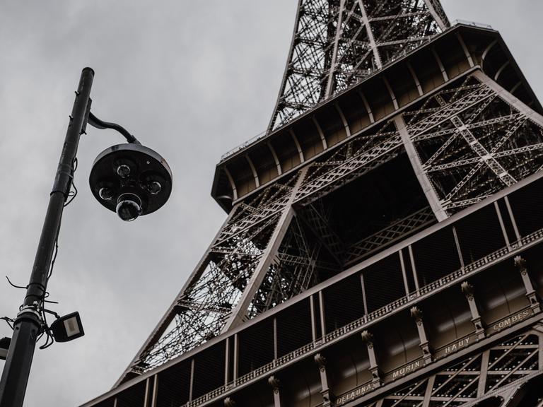 Eine Überwachungskamera ist unweit vor dem Eiffelturm angebracht. Eine Überwachungskamera ist unweit vor dem Eiffelturm angebracht.