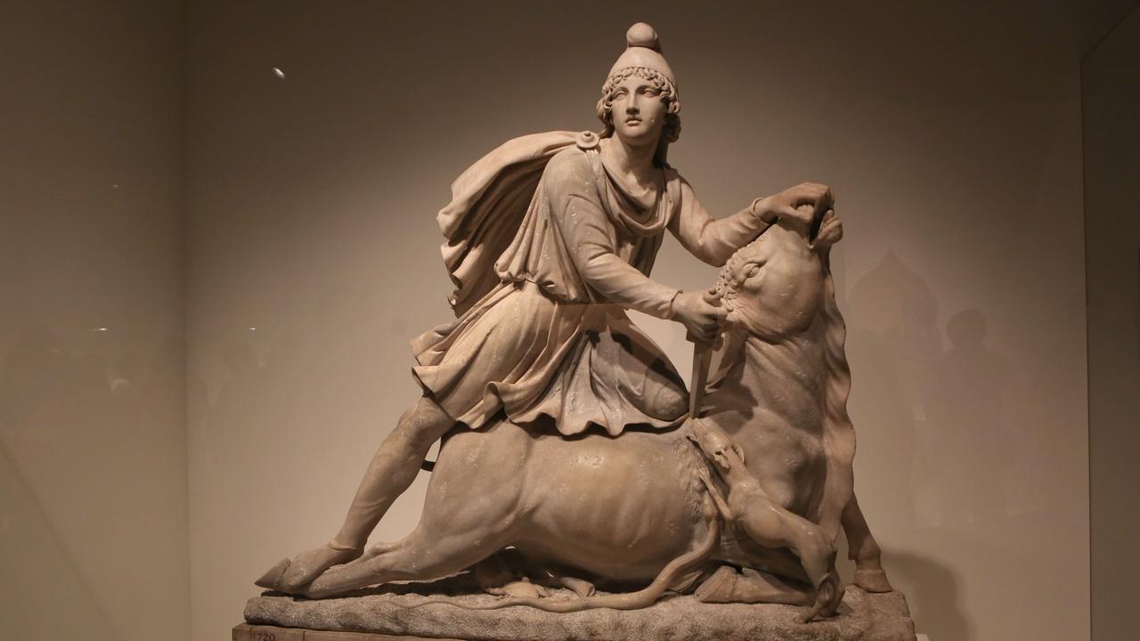 Das Bild zeigt eine Marmorstatue des Mithras während der Ausstellung "A History of the World in 100 Objects", die vom Britischen Museum kuratiert wurde. Mithras selbst trägt die für ihn typische phrygische Mütze und bezwingt einen Stier. 