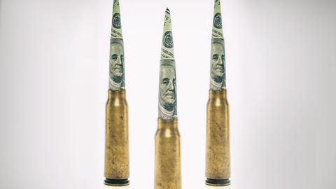 Patronenhülsen auf deren Spitze zu Zylindern gerollte Dollarnoten stecken