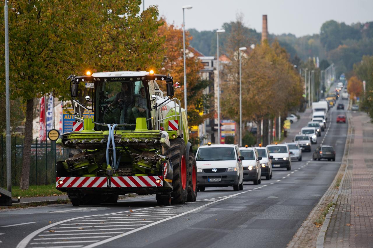 Zittau: Ein Maishäcksler, Laster, Transporter und Autos fahren in einem Korso auf der Löbauer Straße in Zittau. 
