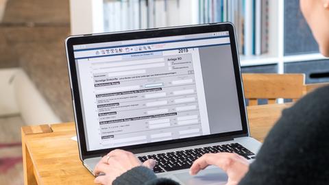 Eine Frau macht ihre Steuererklärung elektronisch an einem Notebook.