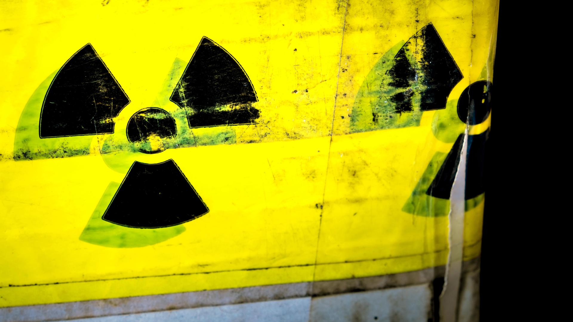 Zu sehen ist das schwarze Symbol für Radioaktivität auf gelbem Grund. Hier: ein Warnschild für radioaktive Stoffe auf einem Paket. Zu sehen ist das schwarze Symbol für Radioaktivität auf gelbem Grund. Hier: ein Warnschild für radioaktive Stoffe auf einem Paket.