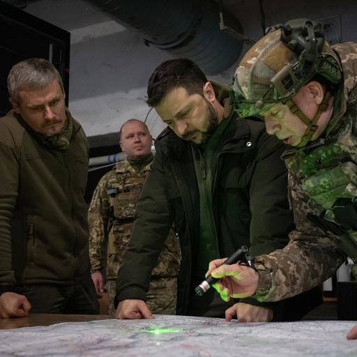 Ukraine, Charkiw: Wolodymyr Selenskyj (M), Präsident der Ukraine, Olexander Syrskyj (r), Oberbefehlshaber der ukrainischen Truppen, und Roman Maschowez, stellvertretender Leiter des Präsidialamtes, betrachten eine Landkarte während ihres Besuchs in der Frontstadt in der Region Charkiw.
