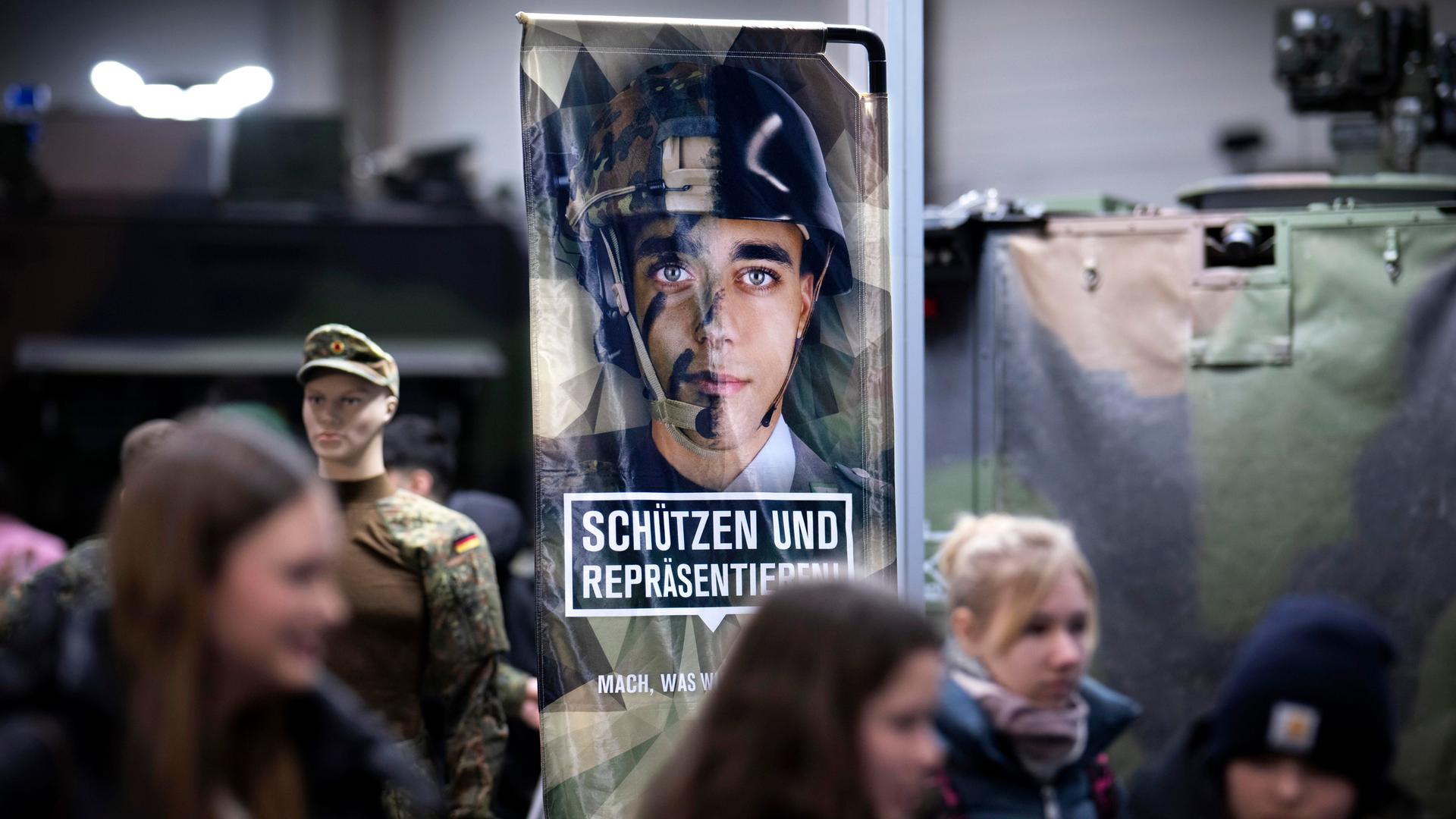 Junge Besucher am Stand der Bundeswehr mit einem Werbeplakat unter dem Slogan "Schützen und Repräsentieren" mit dem Bild eines jungen Menschen in Uniform und Helm, auf der Messe der Internationalen Grünen Woche in Berlin, 2026. Junge Besucher am Stand der Bundeswehr mit einem Werbeplakat unter dem Slogan "Schützen und Repräsentieren" mit dem Bild eines jungen Menschen in Uniform und Helm, auf der Messe der Internationalen Grünen Woche in Berlin, 2026.