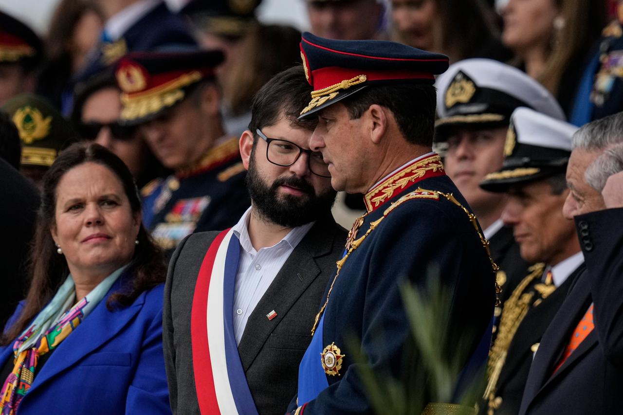 Die chilenische Verteidigungsministerin Maya Fernández Allende (links) steht neben dem Präsidenten Gabriel Boric, der mit dem Oberbefehlshaber General Javier Iturraga spricht. 